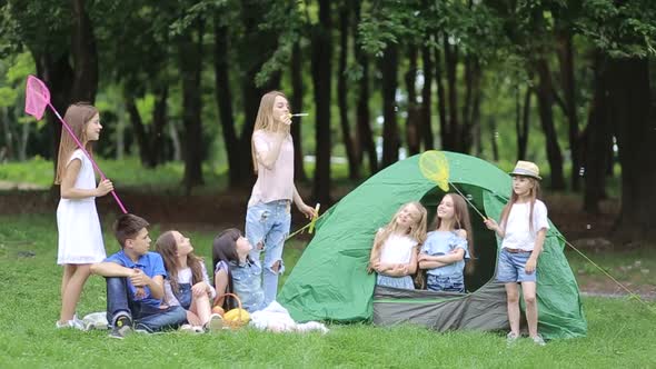 Family picnic in nature. Children with their mother fry marshmallows on skewers