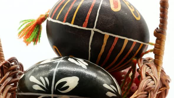 Decorative Basket with Painted Easter Eggs on White Background