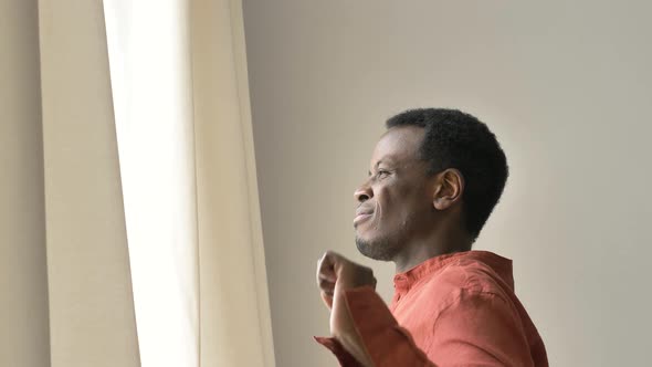 AfricanAmerican Guy Yawns and Opens Curtains in Bedroom