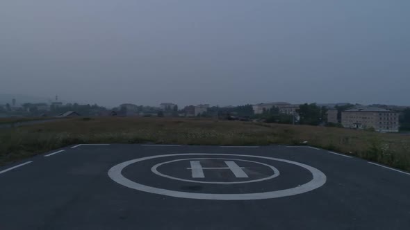 Drone aerial footage of asphalted helipad for helicopters in field