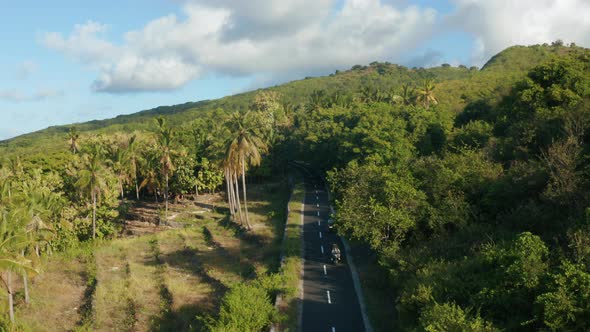 Aerial footage of people is driving the motorbike in Nusa Penida Island.