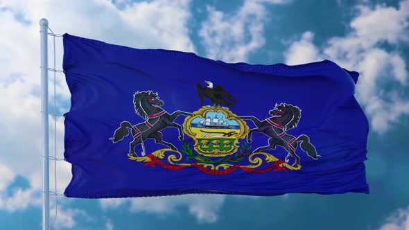 Pennsylvania Flag on a Flagpole Waving in the Wind Blue Sky Background