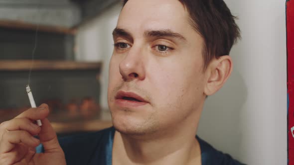 Pensive Transgender Man Smoking Cigarette at Home