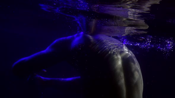 Naked Muscular Man Is Moving in Pool, Underwater Shot, Brawny Back and Arms