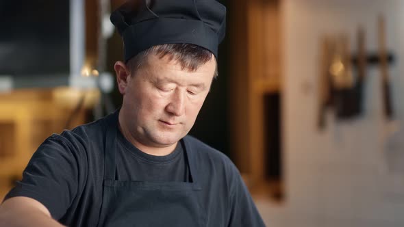 Focused Korean Chef in Black Uniform Mix Food Preparing on Cooker at Kitchen