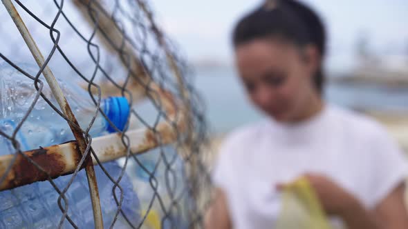 Closeup Container for Plastic Bottles with Blurred Millennial Woman Putting Trash Inside at