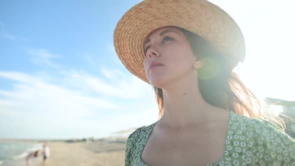 Closeup Portrait of an Attractive Young Caucasian Woman in a Straw Hat and Green Dress