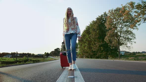 Cheerful Woman with Suitcase Walking on Road.