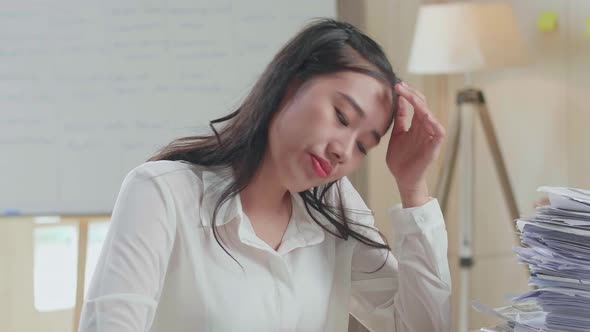 Close Up Of Tired Asian Woman Shaking Her Head While Working Hard With Documents At The Office