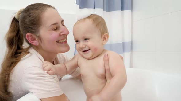 Portrait of Happy Smiling Mother with Baby Boy Having Soap Bath