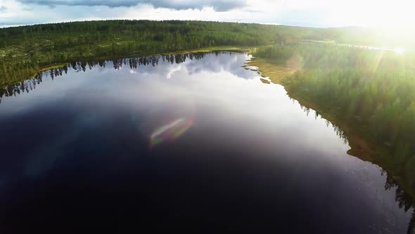 Aerial wide shot of a lake in Sweden. The sky gets reflected in the lake.