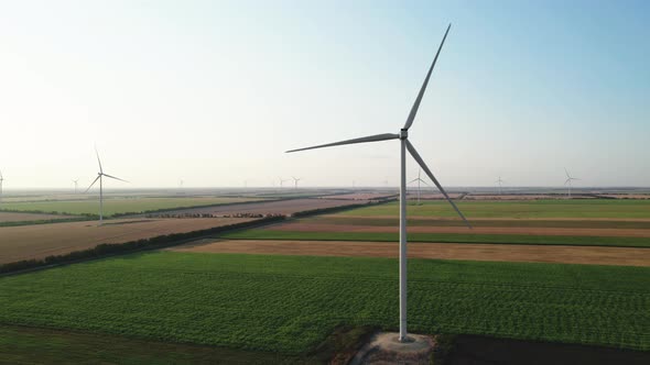 Many Wind Turbines with Rotating Blades Against the Blue Sky