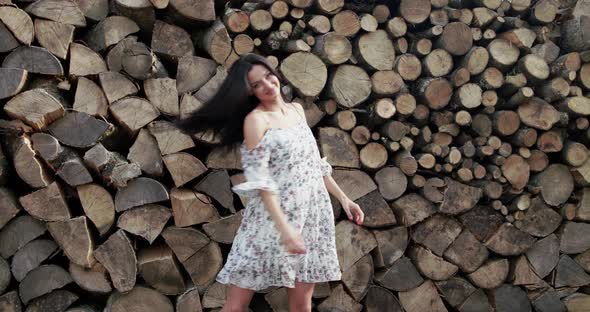 Joyful Lady in Soft Dress Whirling and Posing at Camera on Wood Background