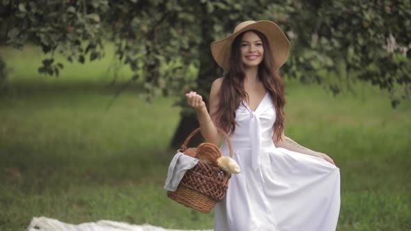 Gorgeous Woman with a Basket in Park.