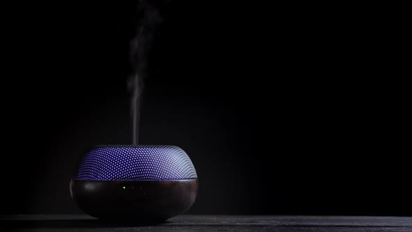 Diffuser for Essential Oils Diffusing Steam on Black Background