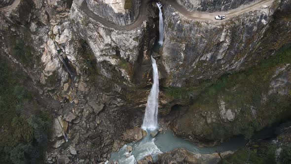 Aerial view of road carved into cliffs at waterfall over the Marsyangdi River