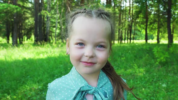 A Little Girl Laughing in the Park in Summer