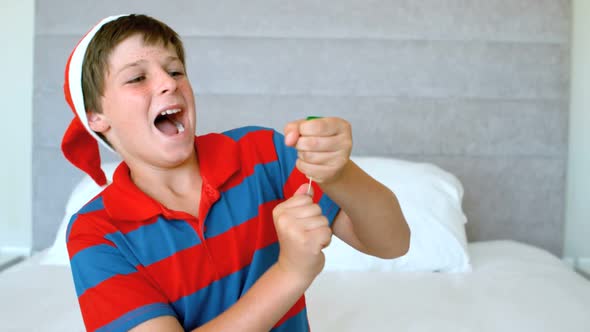 Happy boy using party popper in the bedroom