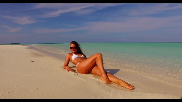 Female model happy and smiling on tropical island beach wildlife by turquoise water with clean sand 