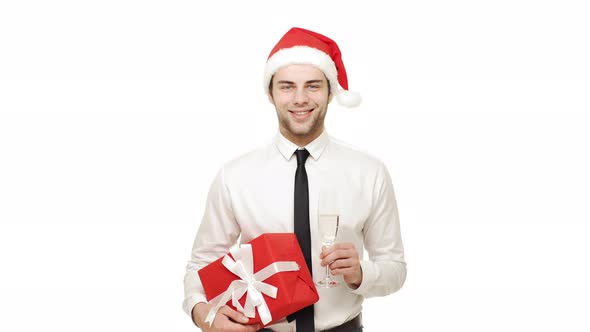 Handsome Young Blond Businessman Wearing Christmas Hat Holding Glass of Champagne Smiling Laughing