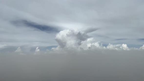 Awesome pilot POV from a jet cockpit with a threatening cloud ahead, flying between layers of clouds