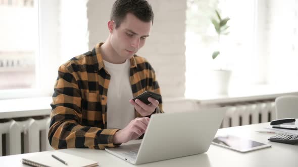 Casual Young Man Talking on Phone for Work