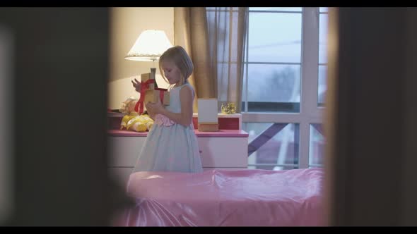 Little Caucasian Girl Holding Casket and Taking Something Red Treasure From It