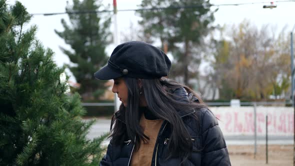 A beautiful woman in a happy holiday spirit smiling while shopping for festive douglas fir Christmas