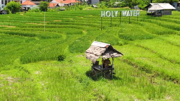 Aerial shot panning semi circle around a couple relaxing and sitting in a small hut in the middle of