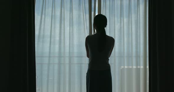 Woman open curtain at the morning