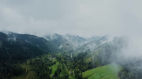 A Green Mountain Valley with Cottages in a Lowland Among Sloping Mountains