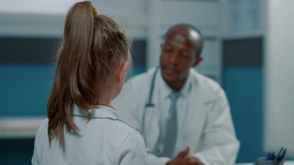 Little Girl with Disease Talking to General Practitioner in Cabinet