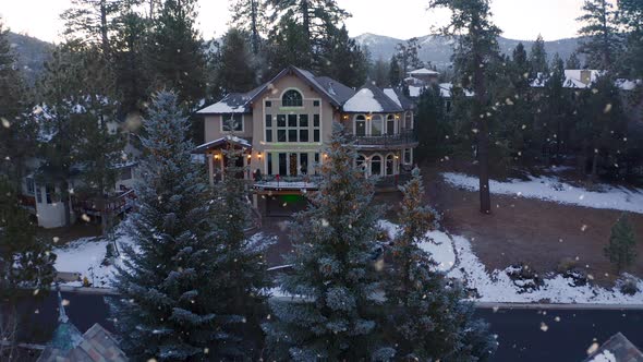 Christmas Decorated Family Home in Snowy Winter Town, Aerial Pull Away Shot