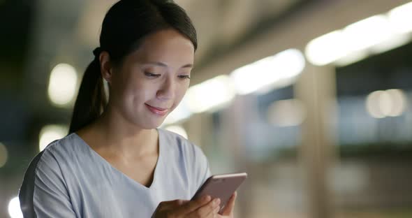 Woman work on cellphone at night