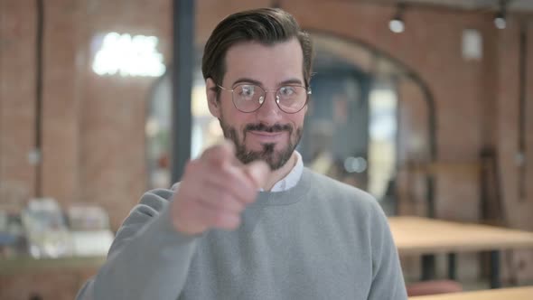 Portrait of Young Man Pointing at the Camera and Inviting