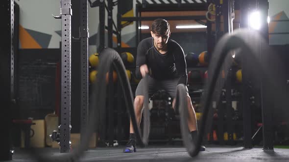 Strong Caucasian Athlete Doing Battle Rope Exercise at Crossfit Gym