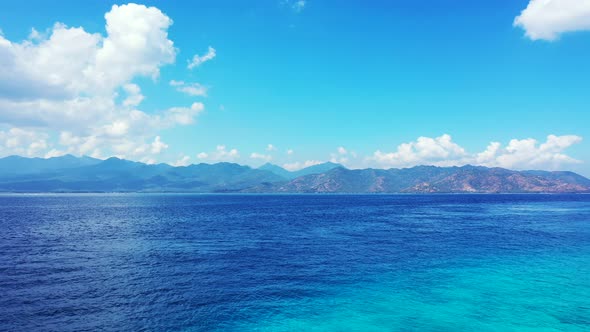 Luxury fly over tourism shot of a sandy white paradise beach and blue ocean background in colourful 