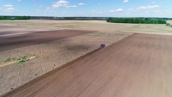 Aerial View Tractor Plows the Land, Processing the Field Before Sowing, Spring