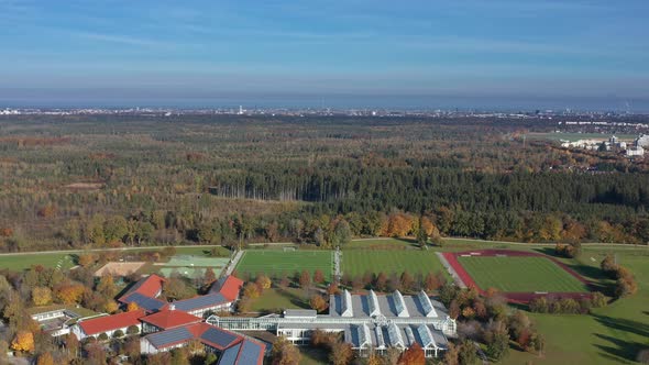 Wide aerial view over several sports grounds with the skyline of Munich, germany in the background b