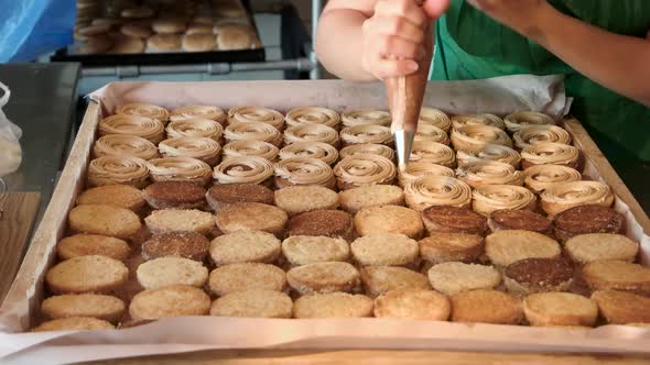 Confectioner Covering Cookies with Cream