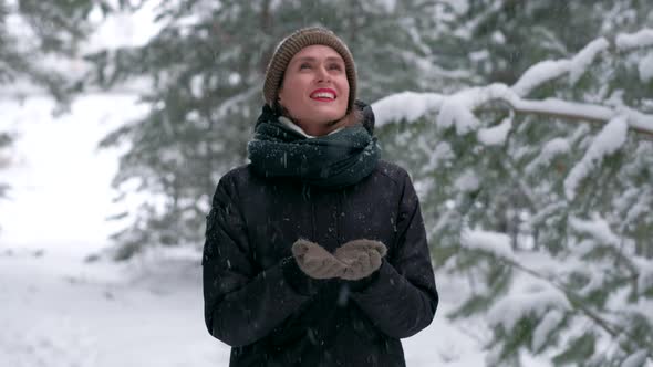 Attractive Female in Winter Forest Catches Snowflakes and is Really Enjoying It
