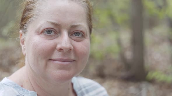 The Smiling Face of the Glad Middleaged Woman at Rest in the Hike She Is Hiding in Woodland From the