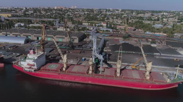 a Cargo Ship Is Moored at the Port Awaiting Loading By Port Cranes