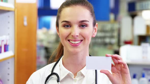 Female pharmacist holding a pill box in a pharmacy