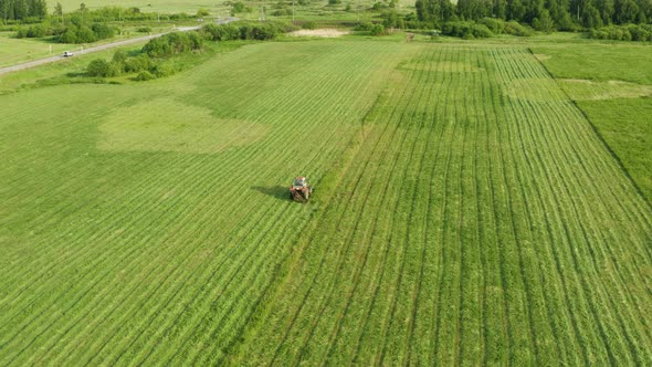 Aerial View Tractor Removes Grass From the Field