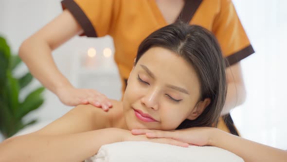 Asian young woman feeling happy and relax during back massage with oil.