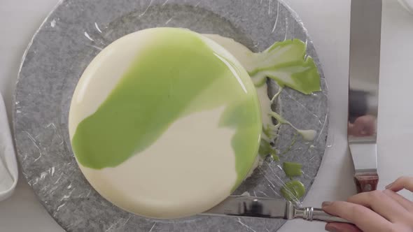 Time lapse. Step by step. Glazing mousse cake with white and green mirror glaze.