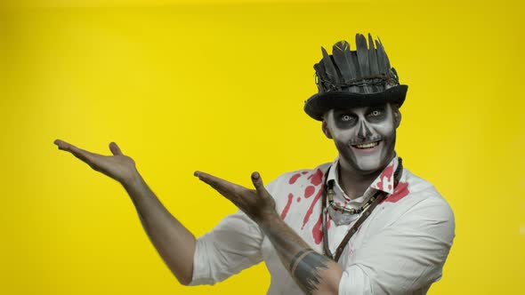 Sinister Man with Horrible Halloween Skeleton Makeup Trying To Scare, Pointing To the Left