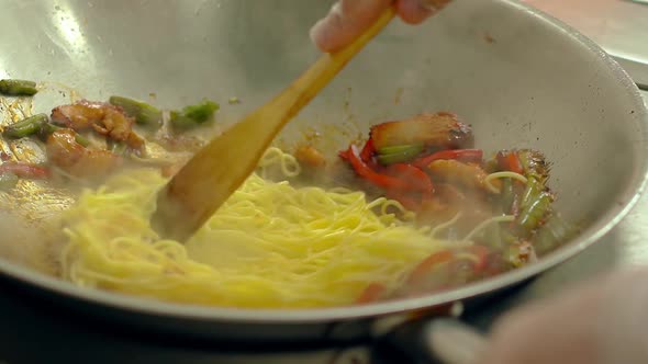 CU, Slow Motion: Cook Prepares Pasta in Frying Pan, in Oil, with Fresh Vegetables