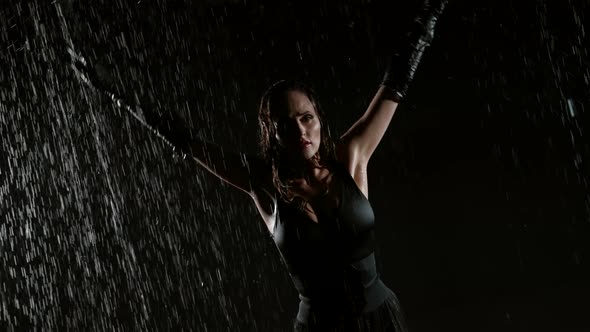 Enigmatic Woman with Sexy Figure is Dancing Under Rain at Night Waving Her Long Wet Hair
